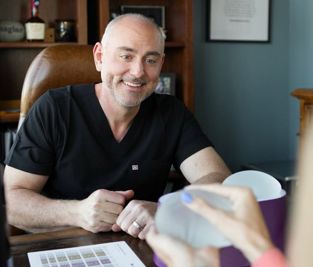 Dr. Dustin Reid explaining a patient about breast augmentation treatment at Restora Austin Plastic Surgery Centre in Austin, TX